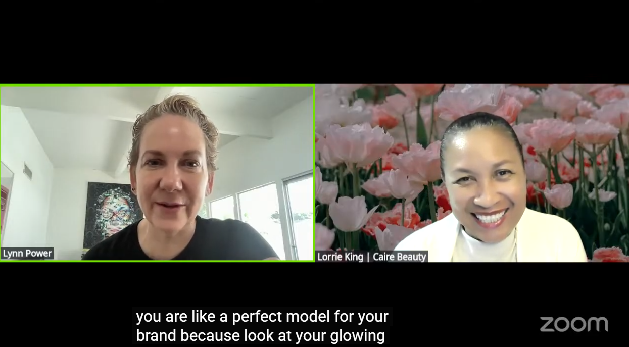 A split-screen Zoom interview with two women, Lynn Power on the left and Lorrie King from Caire Beauty on the right, with a black bar at the bottom containing subtitles and a Zoom logo.